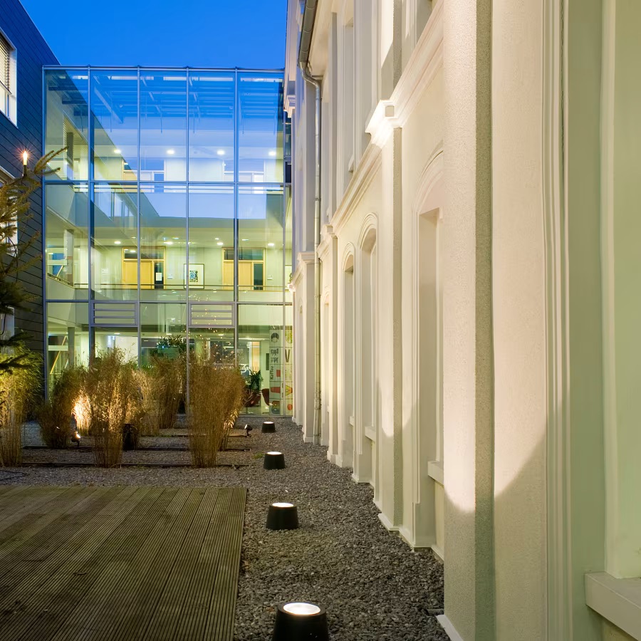 Projecteur à poser au sol noir qui diffuse une lumière agréable pour mettre en valeur la végétation ou des objets