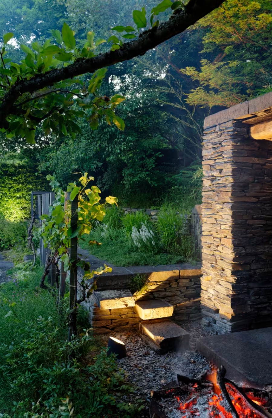 Projecteur à poser au sol noir qui diffuse une lumière agréable pour mettre en valeur la végétation ou des objets